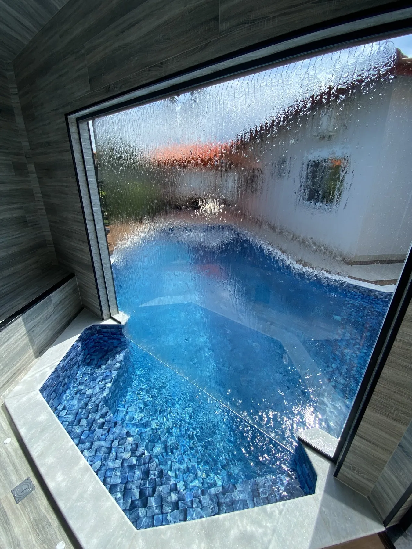Vista de dentro da área coberta para a piscina